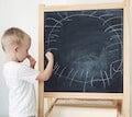Kid next to chalk board